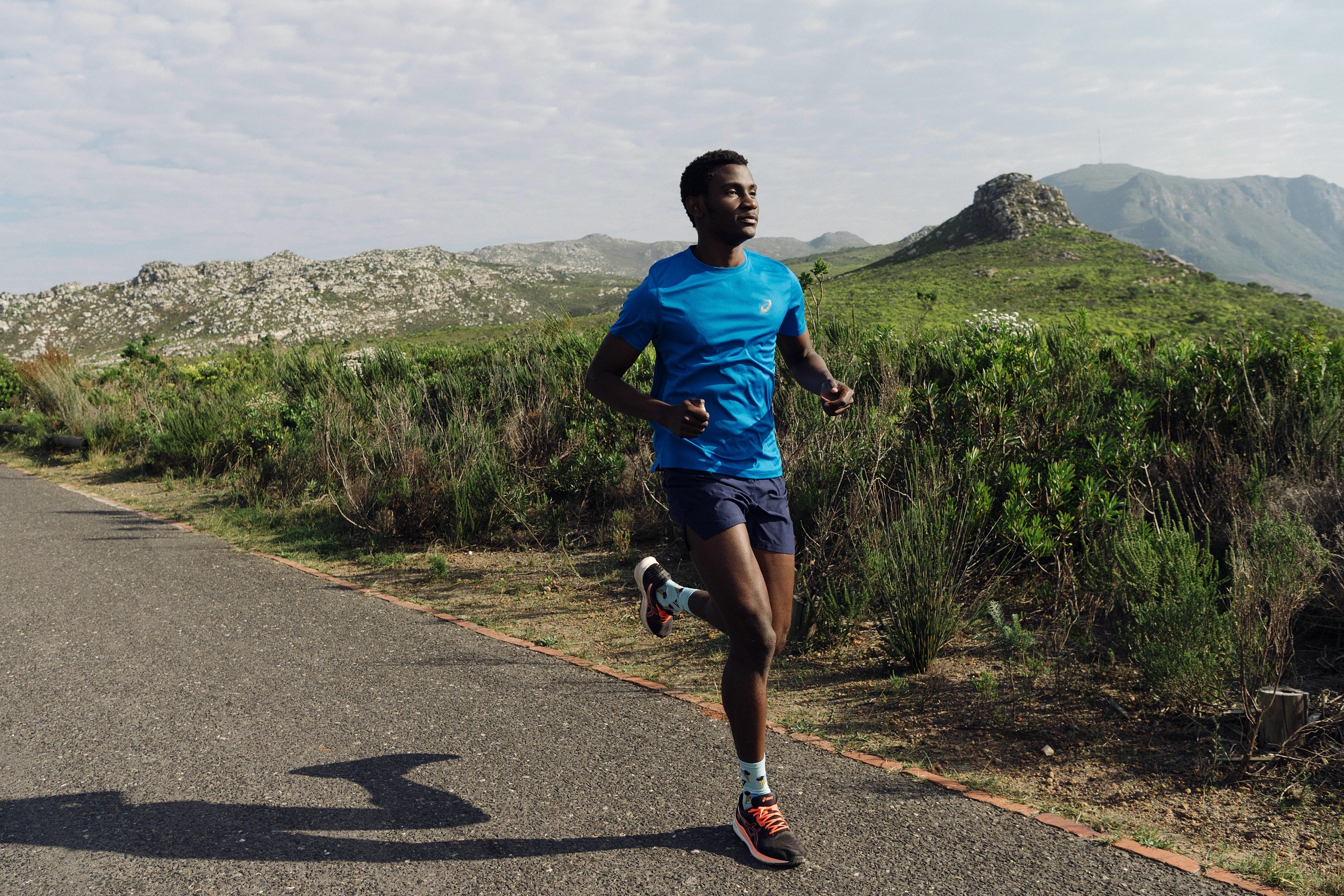 Alexander Hwande running on a quiet road through the mountains