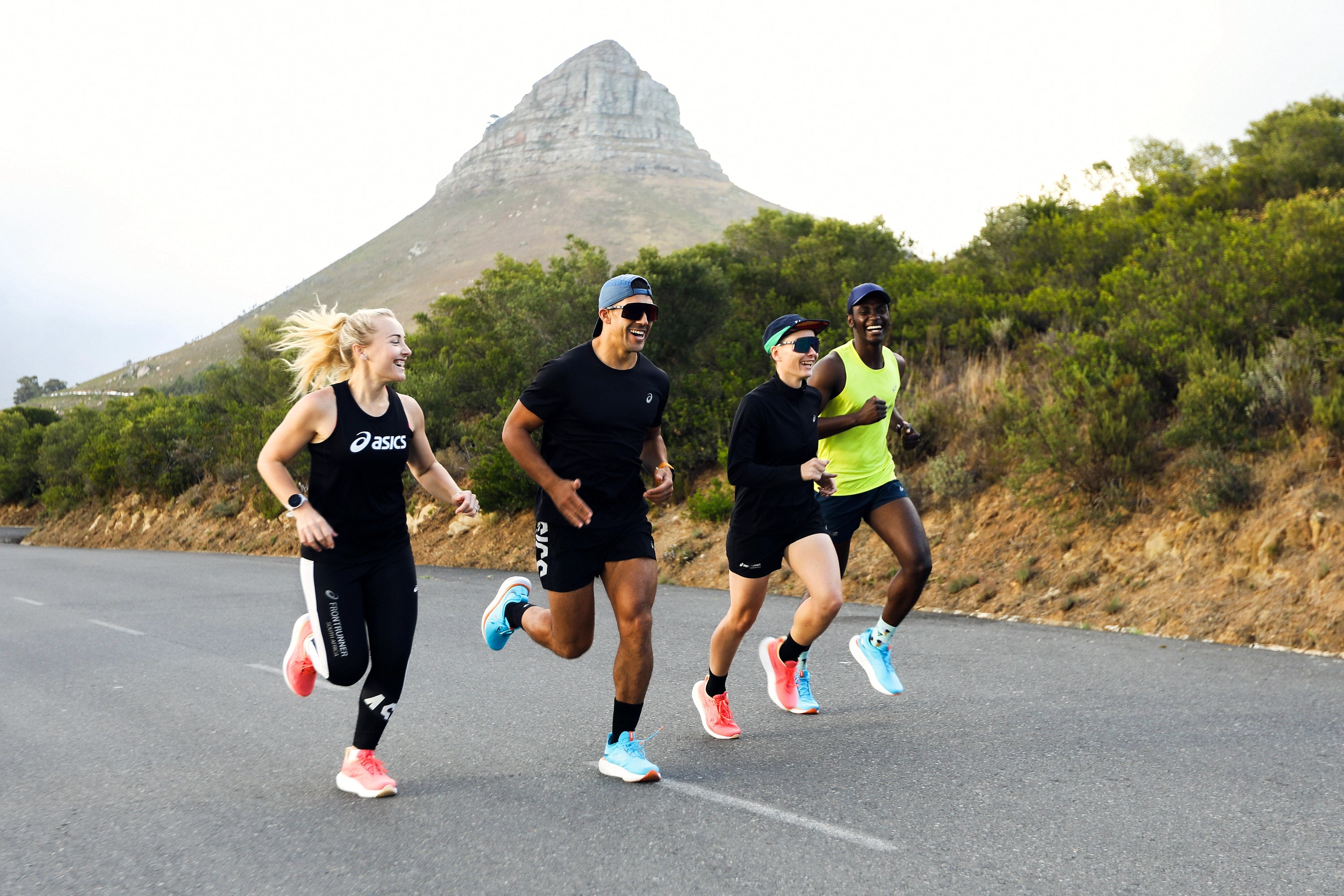 Alexander Hwande running with three other runners below Lion's Head
