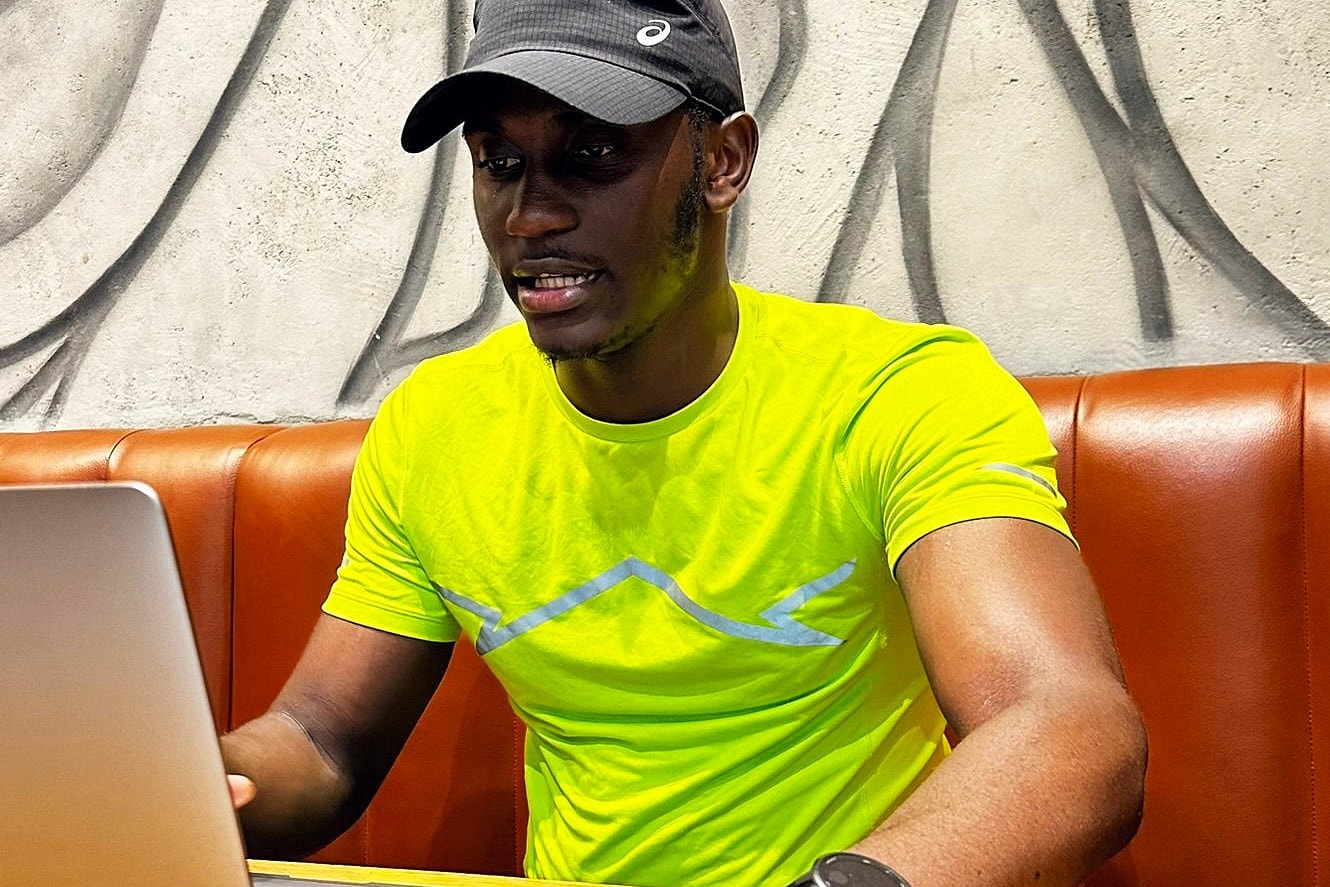 Alexander Hwande working at a laptop in a café
